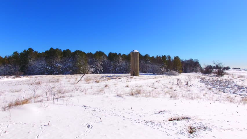 Scenic snow covered woods and fields with abandoned silo, rural Wisconsin.
