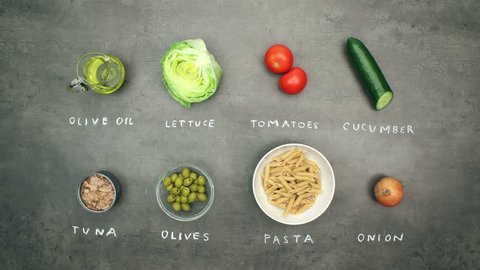 Tuna salad with pasta and vegetables. Top view on recipe ingredients and preparation on grey kitchen table. Stop motion animation and timelapse eating.