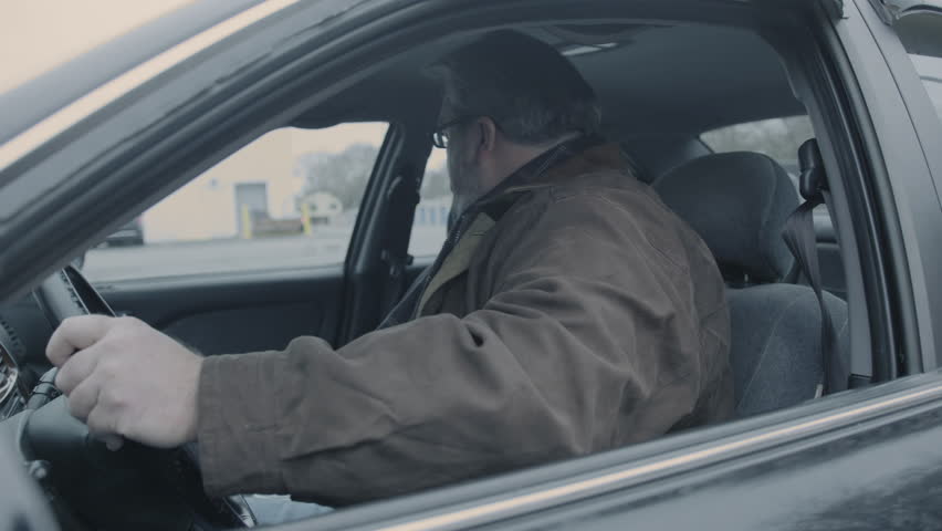 Overweight man eating fast food in car