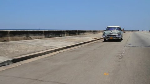 HAVANA/CUBA– MAY 29 2015: Driving Vintage car on highway near ocean