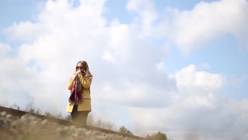 Girl in red shoes walking on the rails. Girl traveling.