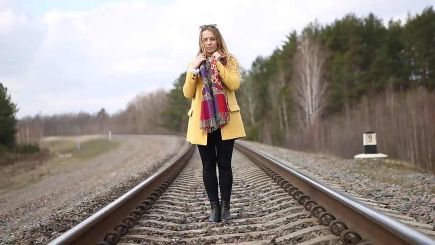 Girl in red shoes walking on the rails. Girl traveling.