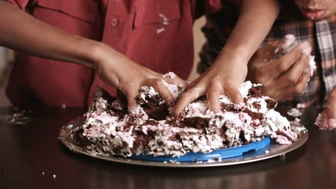 Hands of children destroying cake. Kids smash cake with hands. Neighbour gets his revenge. It's already enough.