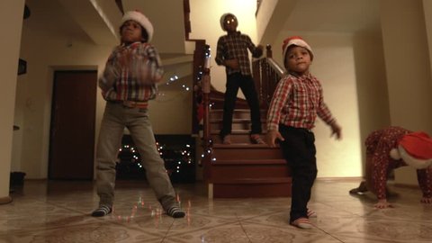 Kids in Santa hats dancing. Children dance freely on Christmas. Good way to express feelings. Time for a holiday dance.