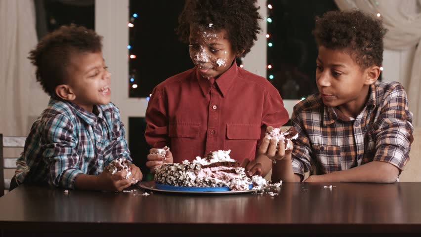 Afro boy's face smashing cake. Kid smashes cake with face. Have a small bite. Here's a true gourmet. Royalty-Free Stock Footage #15588394