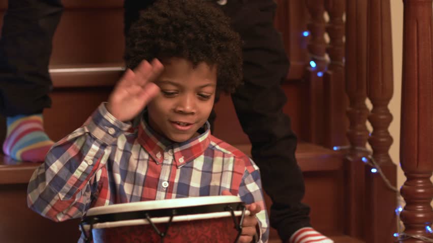 Smiling boy playing on drum. Young cheerful mixed-race with drum. Let