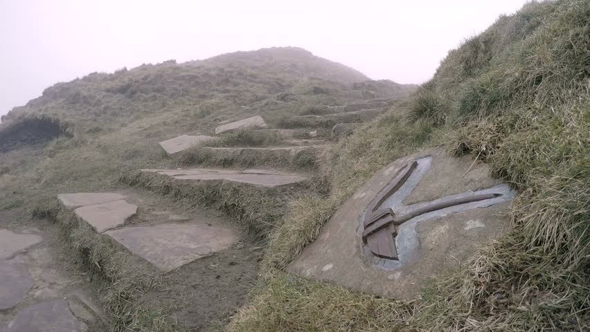 Man descends misty steps in the English Peak District from the Mam Tor
