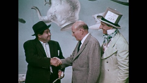 UNITED STATES 1960s: Journalist Talks to Professor at Mad Hatter's Tea Party