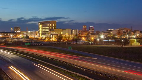 Durham NC City Skyline Timelapse with Fast Moving Interstate Vehicle Traffic during Sunset from Day to Night
