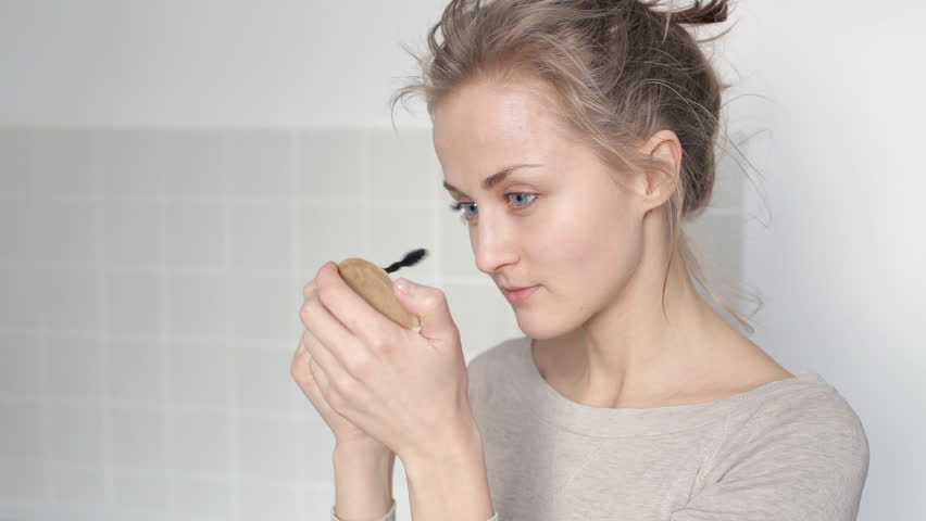 Young girl applying mascara