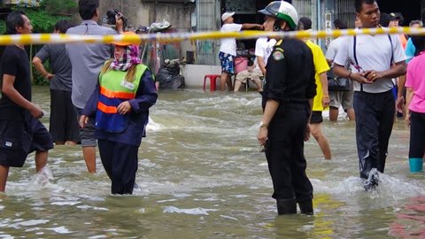 BANGKOK - OCT 30: Unidentified residents of Bangkok's Dusit district make their way through flooded streets after the Chao Phraya River bursts its banks on Oct 30, 2011 in Bangkok, Thailand.