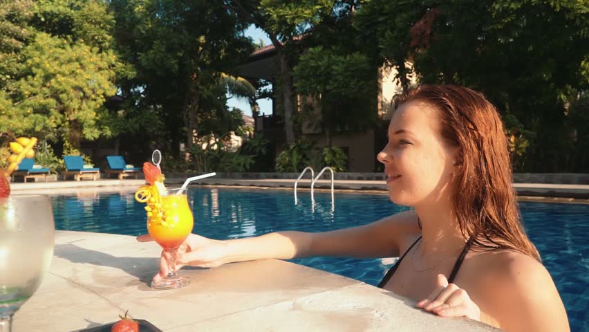 Young woman in a sunken pool bar in a swimming pool