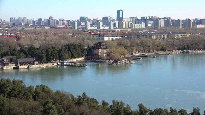 East causeway of the iced Kunming lake (Summer Palace) with the Beijing skyline on background. China.