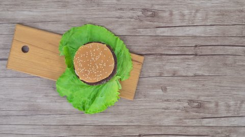  Hamburger on wooden background, stop motion, 4K