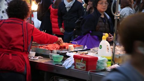 Seoul_30 March 2016 : Senior woman preparing Korean traditional street food, stir-fried Rice Cake (Topokki) to sell on Myeongdong street in Seoul, South Korea 