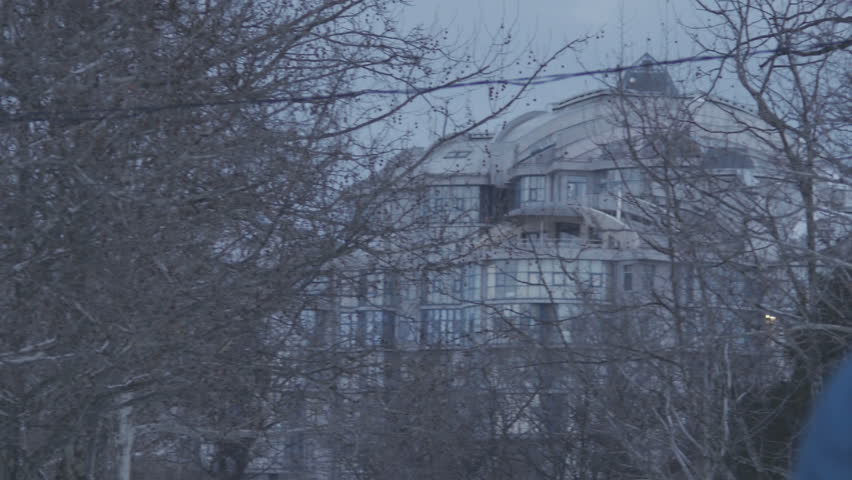 People walking on snowy road in front of the building in cold winter day