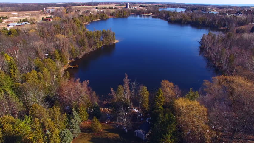 Aerial view of landscape with lakes and farms as far as the eye can see. This is West Alaska Lake in Wisconsin. In the distance is East Alaska Lake and on the horizon, Lake Michigan.