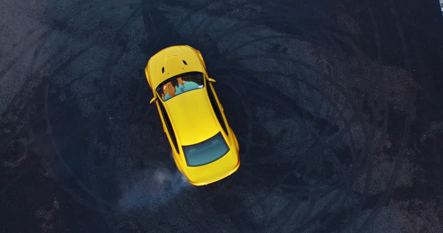 Top view of the golden car drifting on the road. ?ar makes a few laps. Shooting with a drone in 4k.  | Shutterstock HD Video #15627949