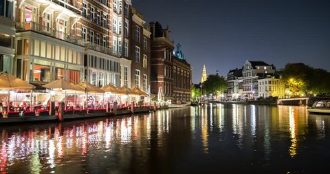 Amsterdam, Netherlands - Canal with boats at night in downtown Amsterdam - Timelapse