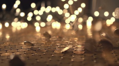 Pile of coins falling on the yellow table. Economic and financial crisis. Salary fall and pension increase, heap or bunch funds for buy for people. Close up of capital indoors. Studio slow motion