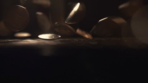 Pile of coins falling on the golden table. Economic and financial crisis. Salary fall and pension increase, heap or bunch funds for shopping for people. Close up indoors. Studio slow motion. Nobody