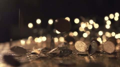 Pile of coins falling on the yellow table. Economic and financial crisis. Salary fall and pension increase, heap or bunch funds for shopping for people. Close up of capital indoors. Macro slow motion