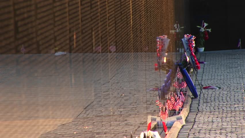 In front of the Vietnam Veterans Memorial Wall, ribbons on tributes and mementos flutter in the breeze.