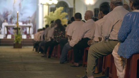 People sit at night easter service in Catholic church 