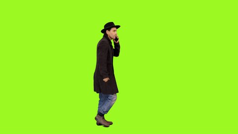 Side view of a man walking & talking on smartphone, Full HD footage with alpha channel