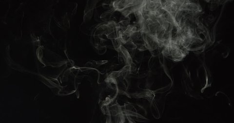 Wisps of turbulent smoke from a candle or cigarette rise into frame and swirl in slow motion on black background, ALPHA MATTE