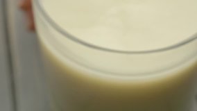 Adding creamy oat milk liquid to bowl of wet and dry flour baking ingredients includes sound, 4K 30p