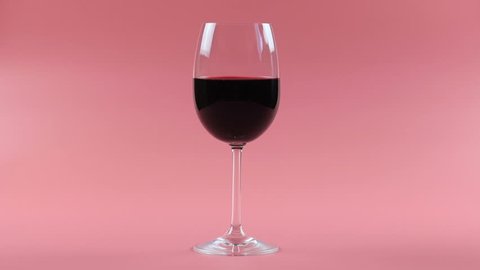 woman drink red wine. Studio setting on a pink background. High definition video
