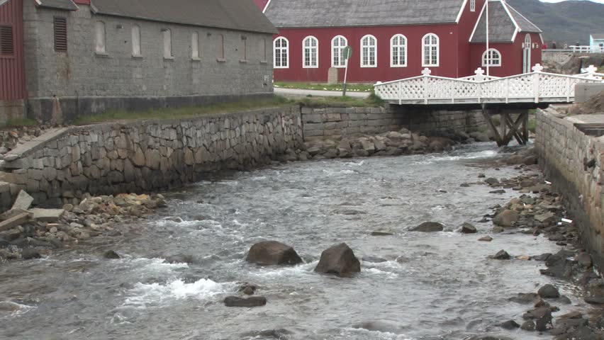 Fast running stream passing Saviours Church in Qaqortoq, Greenland