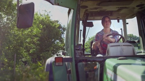 UK, JULY 2015: Farmer driving her tractor. Bramletye Fruit Farm, Forest Row,Sussex, UK july, 2015
