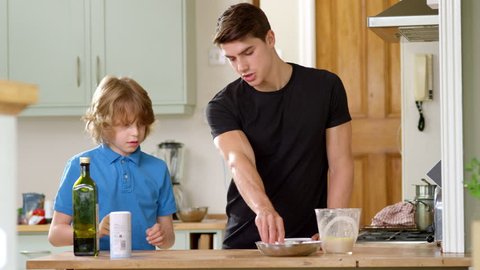 Young brother helping older brother to make Pizza for Dinner
