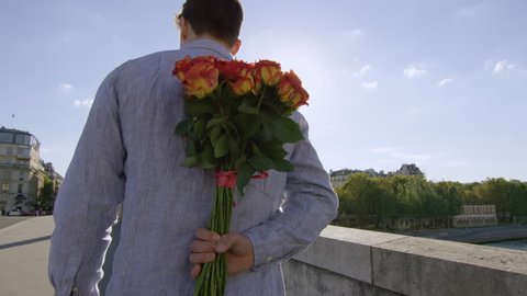Young man gives his lady a bunch of roses and a big kiss while in Paris- Paris, France