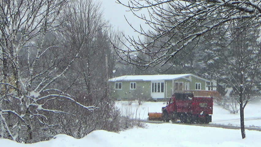 Residential winter landscape with a snow plower in Canada