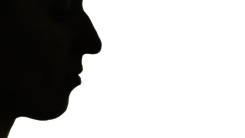 Silhouette shot of a woman blowing into a whistle.

