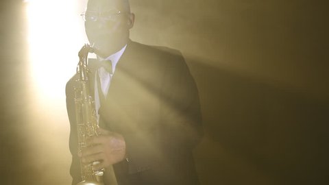 African jazz musician in tuxedo playing the saxophone.