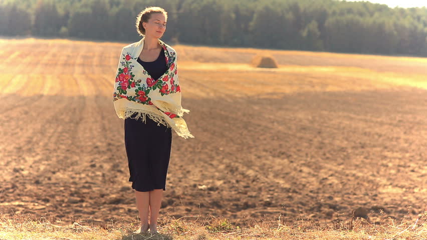 Girl on a background of field in a strong wind. Royalty-Free Stock Footage #15705472