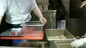 Moving through a professional commercial kitchen in a high-end restaurant.A gourmet kitchen dolly shot with many chefs and cooks at their stations at a large restaurant.