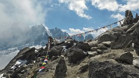 A POV video of an hiker walking along Tibetan prayer flags on the top of Gokyo Peak (5357m) in the Khumbu region, close to Mt Everest, in the Himalayas in Nepal just above the village of Gokyo. 