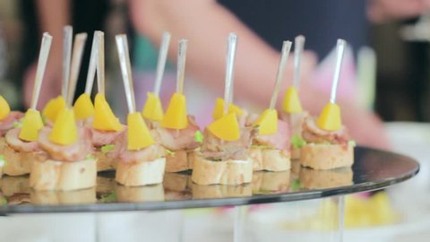 Delicious Canapes and Snacks at the Wedding Banquet. People Impose Food in the Dish.