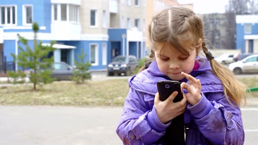 Girl playing in the smart phone on the street