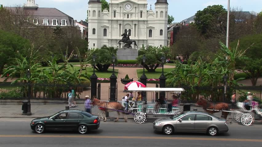 Horse-drawn carriage and traffic passes in front of Jackson Square circa 2006 in New Orleans.