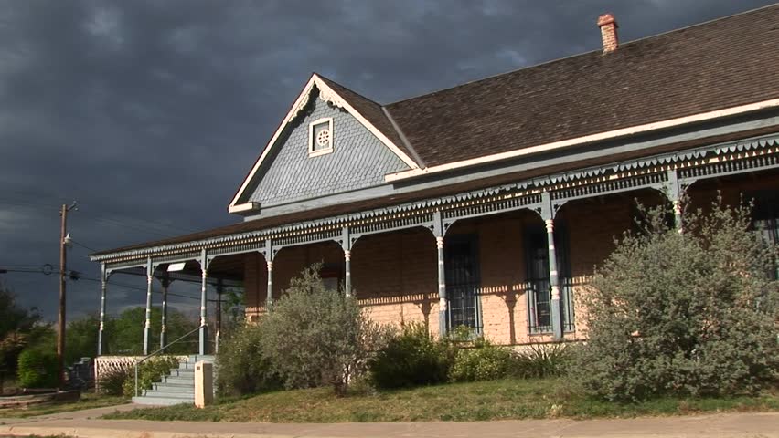 MS of a ranch house as storm clouds gather behind it