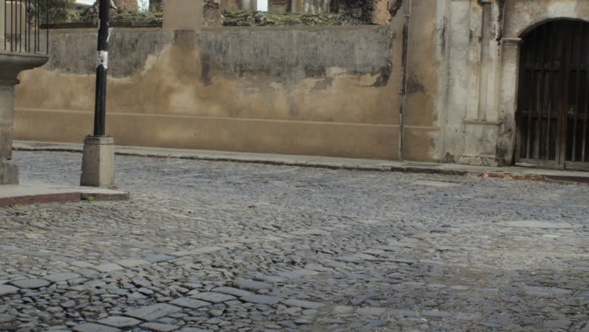 An old decked out school bus drives by the ruins of a church in Antigua, Guatemala. This pimped out school bus has become part of the public transportation system in this Central American Country