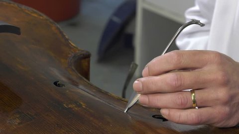 luthier uses special tools to put under presure the soul of the cello