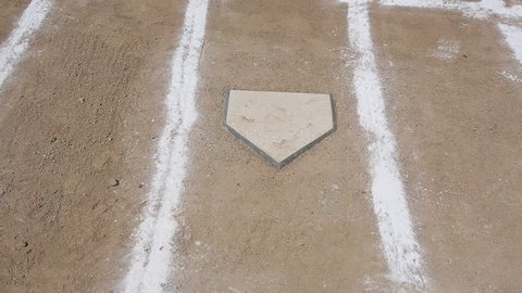 Horizontal pan of a baseball diamond's home plate and batters box chalk lines.