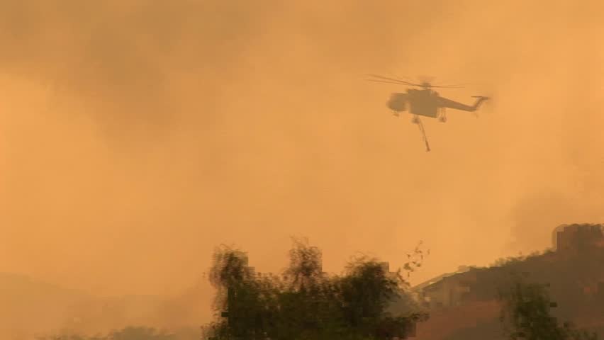 Helicopter dropping chemicals on a wildfire in California